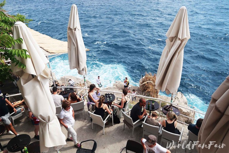 Friends watch waters crash below Buza bar