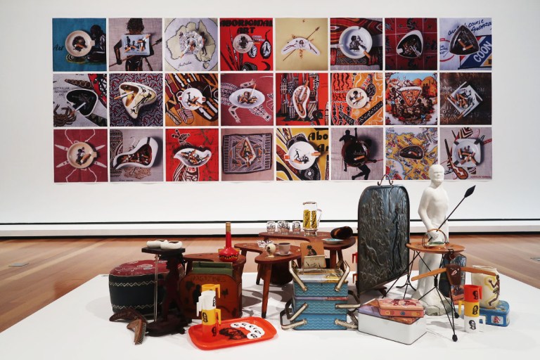 Cigarette butts stamped out in ash trays featuring scenes of Aboriginal life