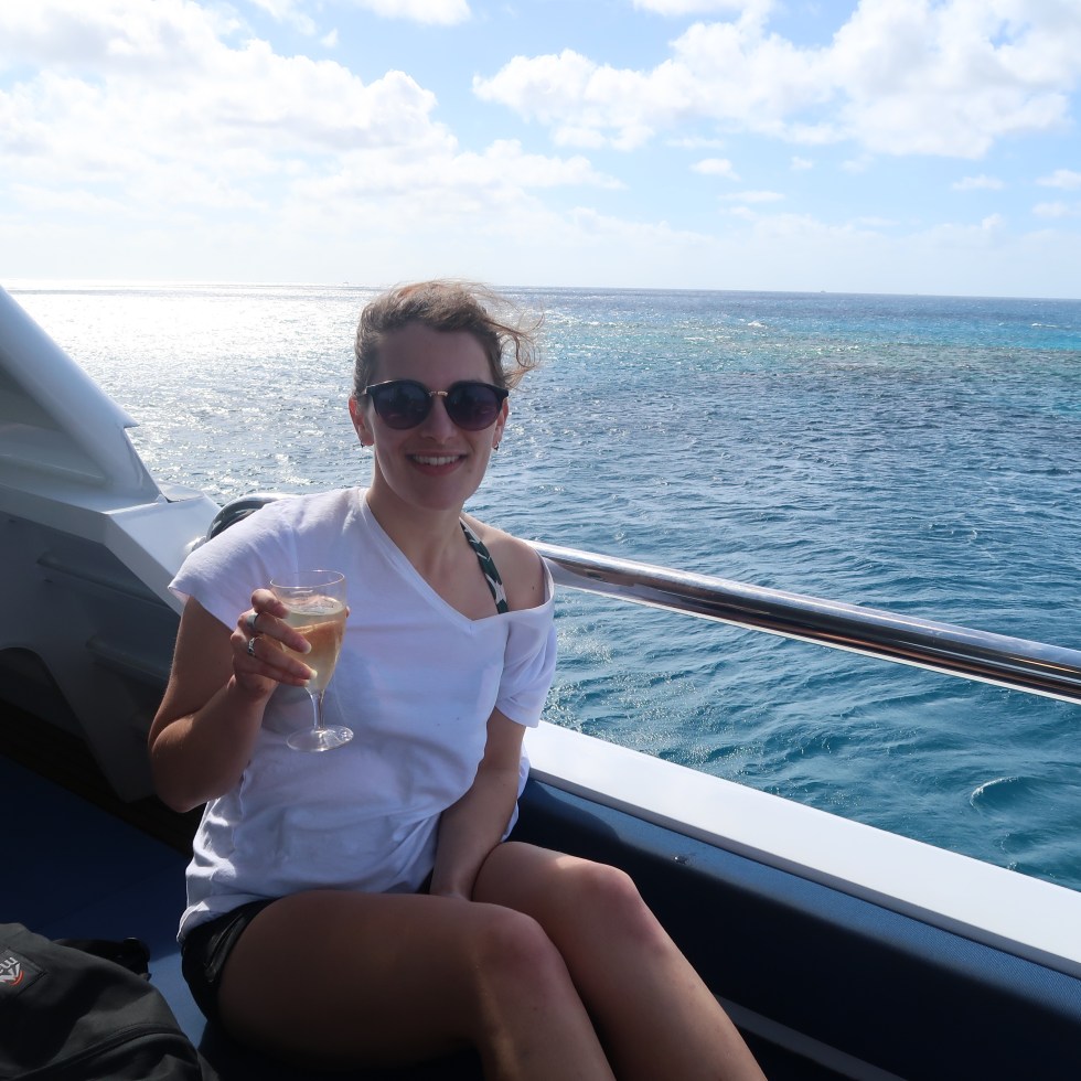 Nikki holding a glass of $2 wine aboard the boat